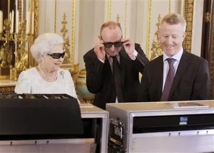 Britain’s Queen Elizabeth watches a preview of her Christmas message with a pair of 3D glasses in London