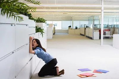 Businesswoman Crying Against File Cabinet