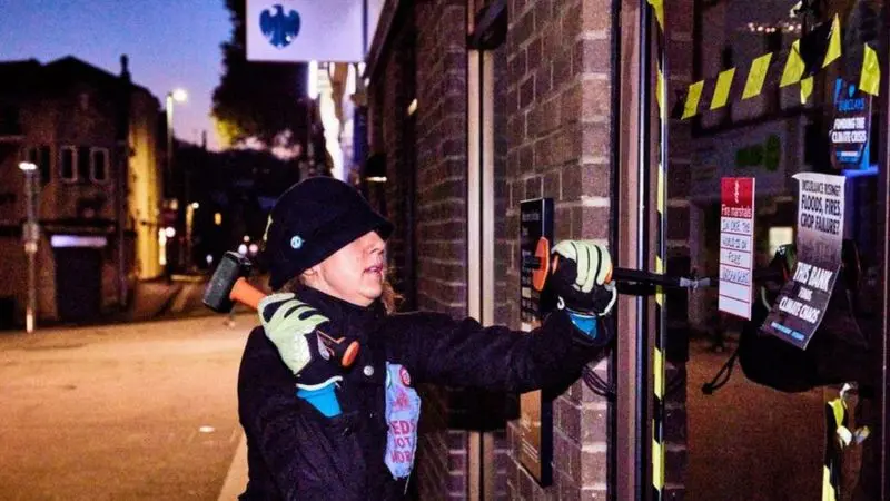 A co-founder of the Extinction Rebellion (XR) group has been fined for smashing the window of a bank.