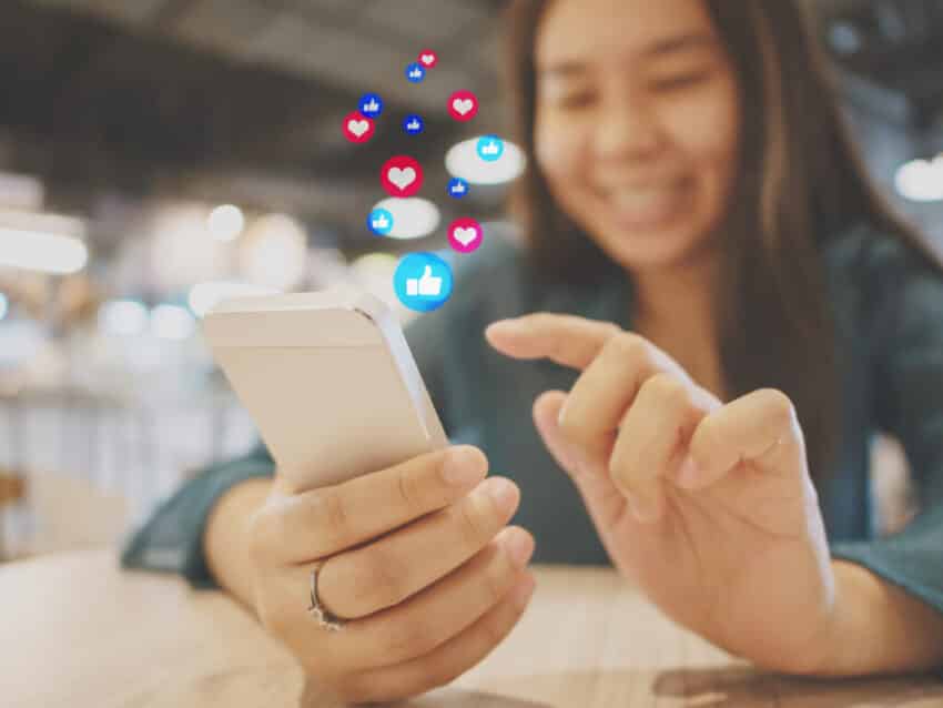 Social network sharing and commenting in the online community. Woman hand holding smartphone and using application social media