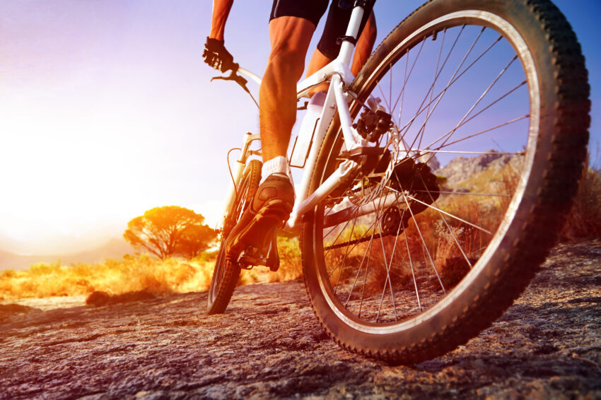 Low,Angle,View,Of,Cyclist,Riding,Mountain,Bike,On,Rocky