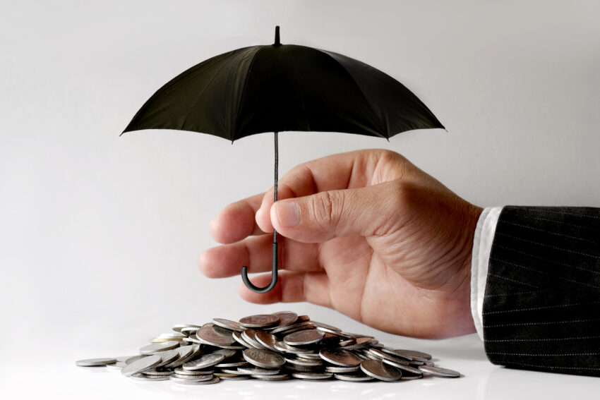 Businessman,Protecting,Coins,With,Umbrella.,Financial,Safety,Concept.