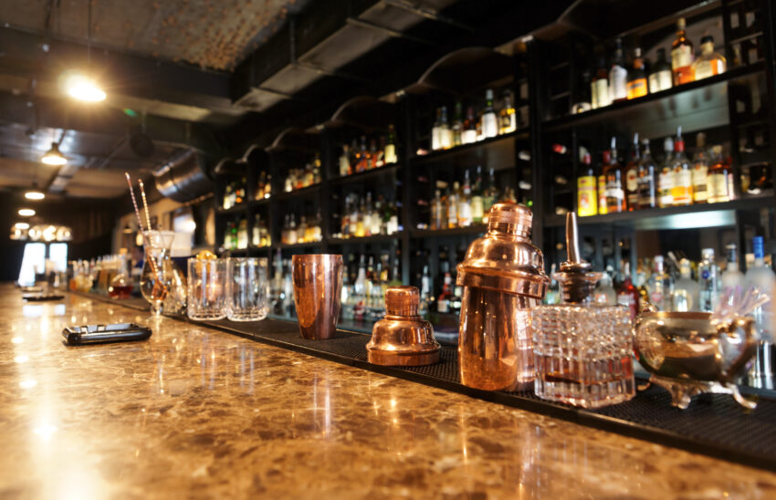 Classic,Bar,Counter,With,Bottles,In,Blurred,Background