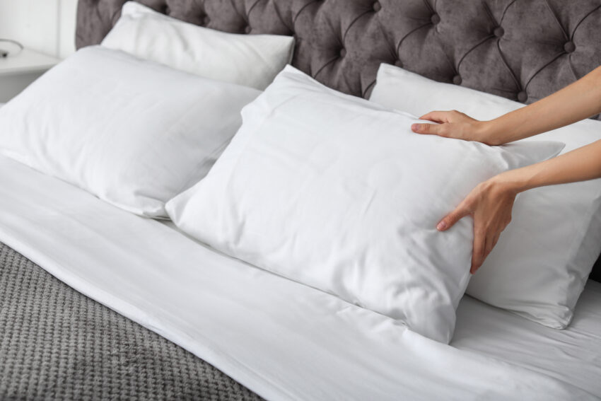 Young,Woman,Plumping,White,Pillow,On,Bed,,Closeup