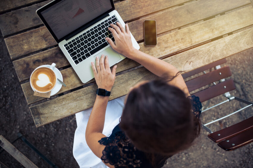 Top,View,Of,Female,Using,Her,Laptop,At,A,Cafe.