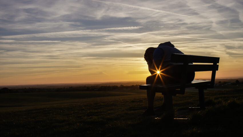 Sad,Unhappy,Silhouette,Man,Sitting,With,His,Head,In,His