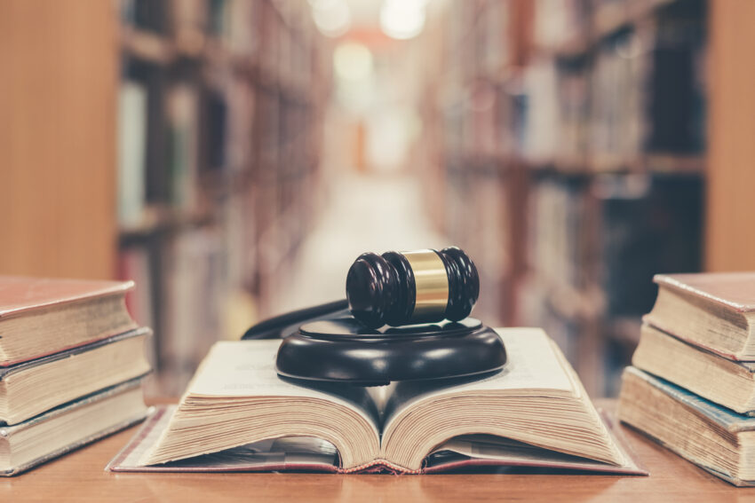 Old,Book,In,Library,With,Judge,Gavel,On,Open,Law