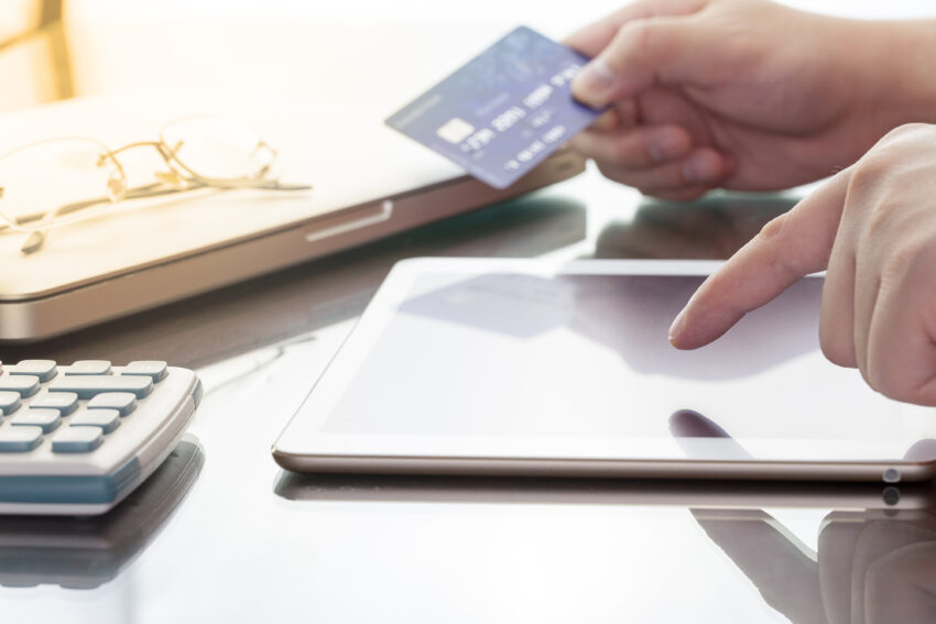 Man,Using,His,Digital,Tablet,While,Holding,A,Credit,Card