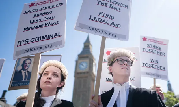 Criminal barristers in England and Wales have voted in favour of an all-out strike next month in a clash with the government over jobs and pay.