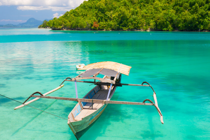 Traditional,Boat,Floating,On,The,Transparent,Blue,Toned,Lagoon,Of
