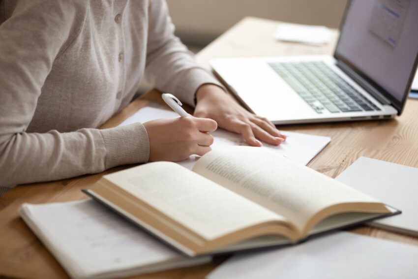 Close,Up,Female,Student,Sitting,At,Desk,,Writing,Down,Notes