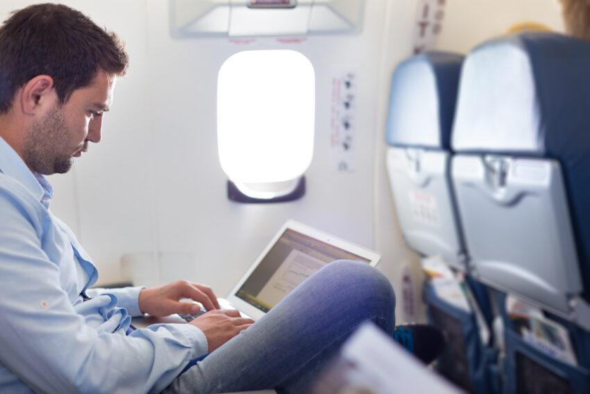 Casually,Dressed,Middle,Aged,Man,Working,On,Laptop,In,Aircraft