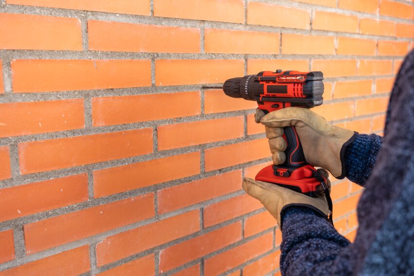 Drilling,Machine,With,Battery,Making,Holes,In,A,Brick,Wall